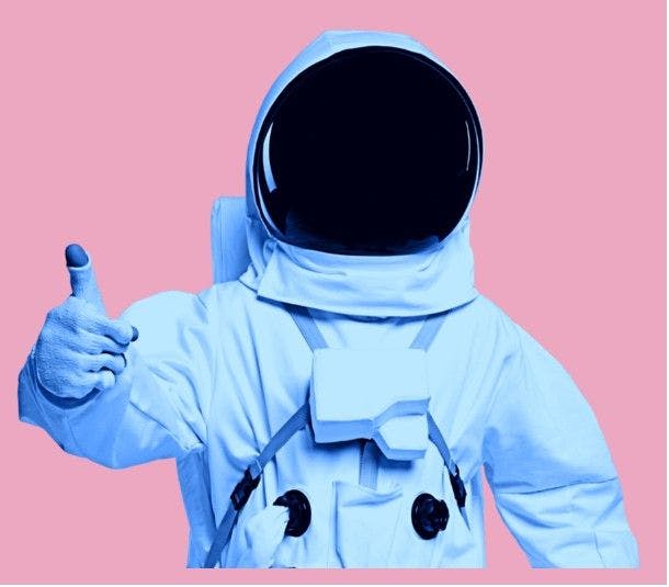 Photographie d'un portrait d'un astronaute sur fond rose levant son pouce de la main droite.